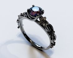 a fancy black gold ring with an amethorate center stone and filigrees