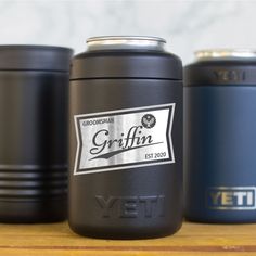 three yeti canisters sitting on top of a wooden table