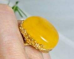 An absolutely gorgeous ring is created of genuine Baltic amber of rich Yellow / Butterscotch color.Beautiful amber gemstone framed in a handcrafted detailed floral style design silver frame plated in 18K Gold. Luxurious and unusual amber jewelry ring is absolutely impressive.This ring is fully adjustable with incomplete ring band.Amber is product of nature a tru historic time capsule created over 45 million years ago. Material: Genuine baltic amber/ Silver/ gold 18K plated Dimensions   :  25 x 2 Luxury Yellow Hallmarked Rings, Luxury Yellow Cabochon Jewelry, Luxury Yellow Rings For Collectors, Elegant Yellow Oval Cabochon Ring, Amber Rings For Formal Occasions, Fine Jewelry, Formal Amber Rings In Fine Jewelry Style, Amber Rings For Formal Occasions In Fine Jewelry Style, Luxury Amber Rings For Formal Occasions, Elegant Yellow Baltic Amber Jewelry