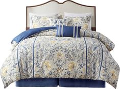 a bed with blue and yellow comforters on it