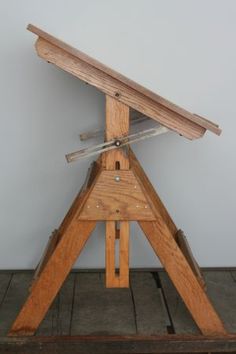 an old wooden table with a metal object on it's top and two swords sticking out of the top