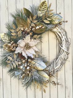 a wreath is hanging on the side of a wooden wall with gold and silver decorations