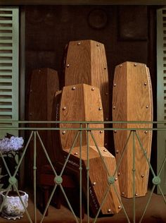 some wooden pieces are stacked on top of each other in front of a window with shutters