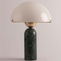 a green marble table lamp with a white shade on it's top and a gold metal base