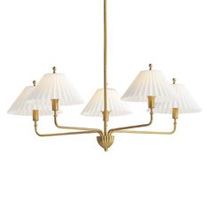 a brass chandelier with three white shades on the lamps and one light fixture