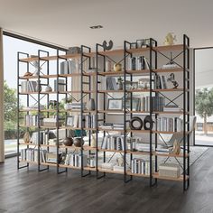 an open bookcase with many books on it in front of a large glass window