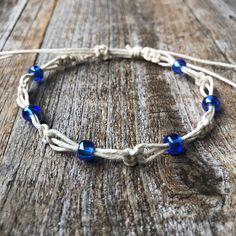 a white and blue bracelet on top of a wooden table