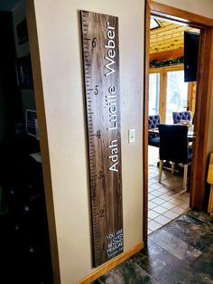 a large wooden ruler hanging on the side of a wall next to a chair and table