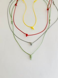 three necklaces with different colored cords and beads