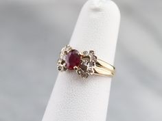 This vintage yellow and white gold ring dates to the late 1950s and has a sweet style and shape. Set with a deep red ruby this is a gorgeous gemstone expertly cut to show off the depths of its ruby red color. Accented by a ribbon of sparkling diamonds this sweet little stylized bow ring is ready to wear or gift to your sweetheart! Metal: 14K Yellow and White Gold Gem: Ruby .50 Carats Gem Measurements: 5.5 x 4.3 mm, Oval Accents: 16 Diamonds totaling .26 Carats, K in Color, I1 in Clarity Ring Siz Ruby Birthstone Ring, Yellow Gold Sapphire Ring, Ruby Birthstone, Diamond Bows, Bow Ring, Cameo Ring, July Birthstone, Ruby Ring, Birthstone Ring