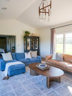 a living room filled with furniture and a chandelier hanging over the top of it