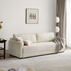 a living room with a white couch and rug