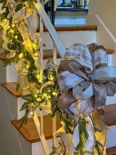 a christmas wreath on the banister with lights and garlands hanging from it's sides