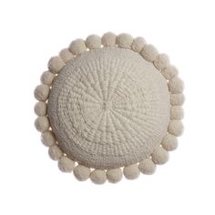 a white round pillow with pom - poms on the top and bottom, viewed from above