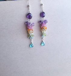 Beautiful rainbow/princess inspired gemstone silver earrings. Made with Amethyst/Light Amethyst, Ruby,Mexican Opal, Citrine, Cats Eye Chrysoberyl, Peridot,Blue Zircon, Blue Apatite, and Sterling Silver.  Measuring at approximately 3 inches long.  Please note that these earrings are not one of a kind, I really like the look and gems of these and I am willing to make another pair.  Free priority shipping to the US. International shipping price is for priority shipping only.  Jewelry comes in a jewelry box and care instructions. Follow the care instructions and your jewelry will surely last you a long time. Treat it like a treasure because that is exactly what it is :) Rainbow Gemstone Jewelry In Sterling Silver, Rainbow Sterling Silver Jewelry For Jewelry Making, Rainbow Sterling Silver Dangle Jewelry, Amethyst Multi-stone Briolette Earrings, Handmade Rainbow Sterling Silver Earrings, Purple Multi-stone Dangle Earrings, Purple Multi-stone Dangle Jewelry, Rainbow Sterling Silver Earrings, Rainbow Sterling Silver Bohemian Jewelry