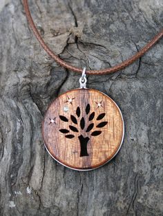 "This beautiful and unique hand-carved Tree wooden necklace will be made for you, or a loved one, in my studio on the West of Ireland. Encircled into a side groove with a sterling silver ring and adorned with abalone shell & silver inlays, this delicately carved Tree of life pendant features a piece of rosewood, recycled from guitars constructed by a local luthier. As a musician myself, I take enormous satisfaction in creating a piece of jewellery whose inherent wood has previously featured Brown Carved Round Pendant Necklace, Holistic Wooden Beads Necklace As A Gift, Holistic Wooden Beads Necklace For Gift, Holistic Style Wooden Beads Necklace For Gifts, Holistic Style Necklace With Wooden Beads, Holistic Style Necklace With Wooden Beads For Gifts, Handmade Wooden Necklace Gift, Gift Wooden Bead Necklaces In Natural Wood, Natural Wood Necklaces With Wooden Beads For Gift