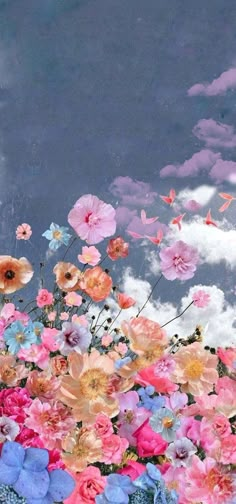 a bunch of flowers that are sitting in the grass with clouds behind them and one is flying through the air