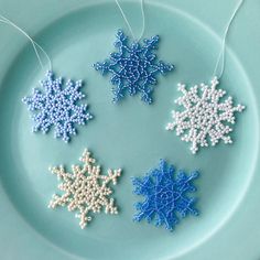 three snowflakes are hanging from string on a plate