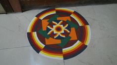 a circular design on the floor in front of a door with an orange, yellow and green flower