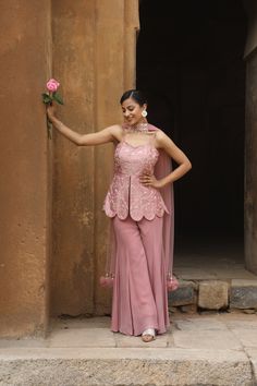 Featuring Onion Pink silk peplum with mirror, zardozi embroidered, paired with georgette inserted sharara and net choker dupatta with our signature hangings. Fabric - Silk, Georgette and net Components - 3 Colour - Onion Pink Embroidery details - Hand Embroidery Delivery time - 2-3 weeks Washing Instructions - Dry-clean