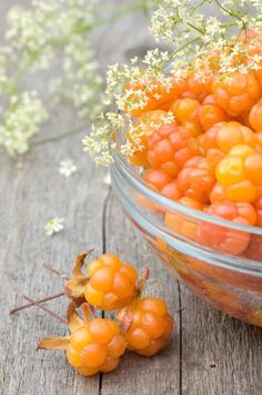 small orange berries in a glass bowl on a wooden table