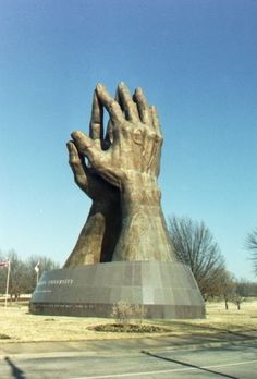 a large hand statue in the middle of a parking lot