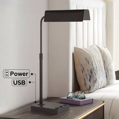 a lamp sitting on top of a table next to a bed