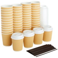 a stack of coffee cups next to a pile of straws and chocolate sticks on a white background