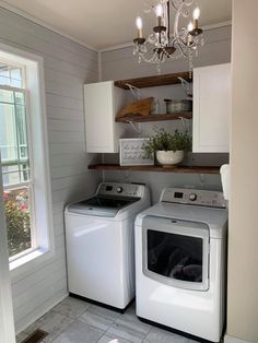 a washer and dryer in a small room with white cabinets on the wall