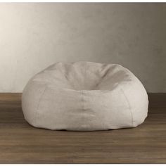 a large white bean bag chair sitting on top of a wooden floor next to a wall