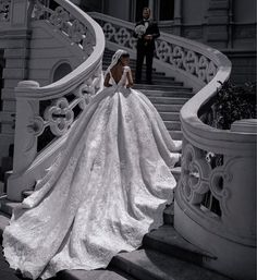 a woman in a wedding dress is standing on the stairs next to a man wearing a tuxedo