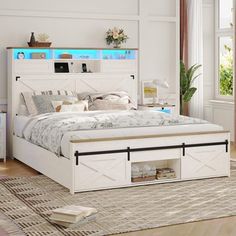 a white bed sitting in a bedroom on top of a wooden floor next to a window