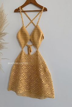 a gold dress hanging on a wooden hanger