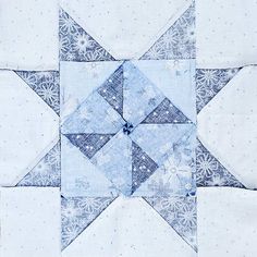 a blue and white patchwork quilt with snowflakes on the top, as if it were an ornament