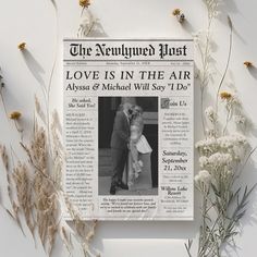 a newspaper with an image of a man and woman on it next to some flowers