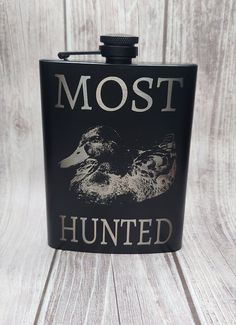 a black flask with the words most hunter written on it and two ducks in front