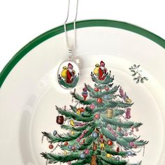 a plate with a christmas tree painted on the front and sides, hanging from a silver chain