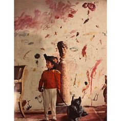 a boy and his dog standing in front of a painting