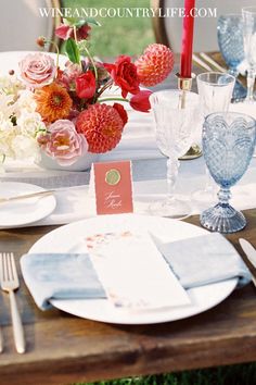 the table is set with flowers and place cards