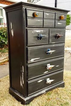 an old black dresser is sitting in the grass