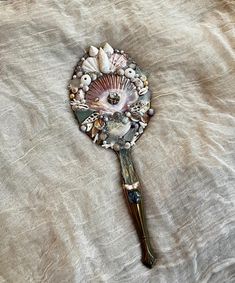 a hair brush with shells and seashells on it sitting on top of a bed