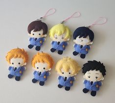 six small felt dolls are hanging from strings