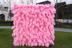 a large pink and white sculpture in the grass