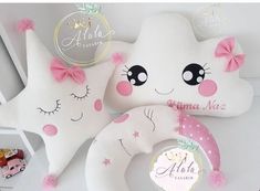 two white pillows with pink bows and stars on them, one is shaped like a cat