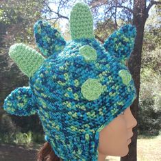 a crocheted hat with green and blue flowers on it