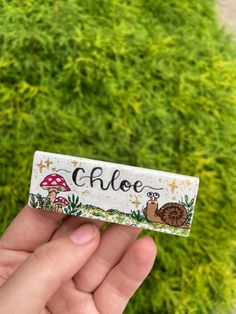 someone is holding up a small business card that says aloe with snails and mushrooms on it