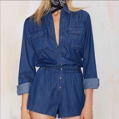 A Sleek Coating Brightens Up The Medium Blue Wash Of A Lightweight Denim Romper Featuring A Long-Sleeve, Button-Front Top Studded With Copper Snaps And Relaxed Shorts. 35 1/2" Length; 2 1/2" Inseam; 28.5” Leg Opening. Front Snap-Button Closure. Spread Collar. Two-Button Barrel Cuffs. 100% Cotton. Machine Wash Cold, Tumble Dry Low. Fits True To Size. Large = 10-12 High Waist Denim Tops For Fall, Fall High Waist Denim Tops, Blue Relaxed Fit Denim Jumpsuit With Button-up, Blue Relaxed Fit Button-up Denim Jumpsuit, Blue Denim Jumpsuit With Relaxed Fit And Button-up Design, Long Sleeve Denim Blue Cotton Jumpsuit, Casual Long Sleeve Denim Jumpsuit, Casual Denim Jumpsuits And Rompers With Long Sleeves, Blue Casual Button-up Jumpsuits And Rompers