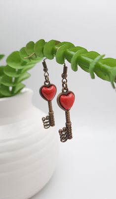 Pictured is a beautiful pair of flat back red cabochon heart earrings, placed within a key bezel. They are the perfect gift for those who loves love and to give love. ❤️  Size of earrings is about 16X11 mm. Material is nickel free and lead free metal, zinc alloy. They hang on a antique bronze earring hook.  As soon as your order is received, I will start the shipping process. I offer free shipping on domestic orders. Your order will come already packed and ready for gift giving or simply for you Red Vintage Heart Earrings For Gifting, Red Vintage Heart Earrings For Gift, Vintage Red Heart Earrings For Gift, Vintage Red Heart Earrings As Gift, Valentine's Day Key Jewelry Gift, Key Heart, Give Love, Bronze Earrings, Earring Hook