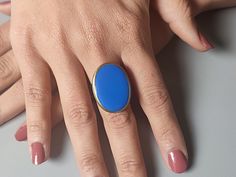 Embrace the bohemian spirit with the rich allure of this oval shaped cabochon Ring, where elegance meets simplicity. 💍🔵 This masterpiece exudes a royal essence, with a stunning blue resin cabochon set in an antique bronze plated setting. More than just a piece of jewelry, this ring stands as a testament to boho and hippie inspirations, blending seamlessly with both costume and cocktail attire. Its sizable design ensures versatility in wear, offering comfort along with style. Designed to be nic Bohemian Oval Cabochon Ring, Elegant Blue Oval Enamel Ring, Gold Oval Enamel Ring, Gold Oval Enamel Ring With Cabochon, Oval Cabochon Enamel Ring Gift, Modern Handmade Oval Rings, Handmade Modern Oval Rings, Big Cocktail, Hippie Ring