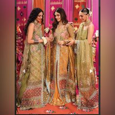 three beautiful women standing next to each other in front of a wall with pink curtains